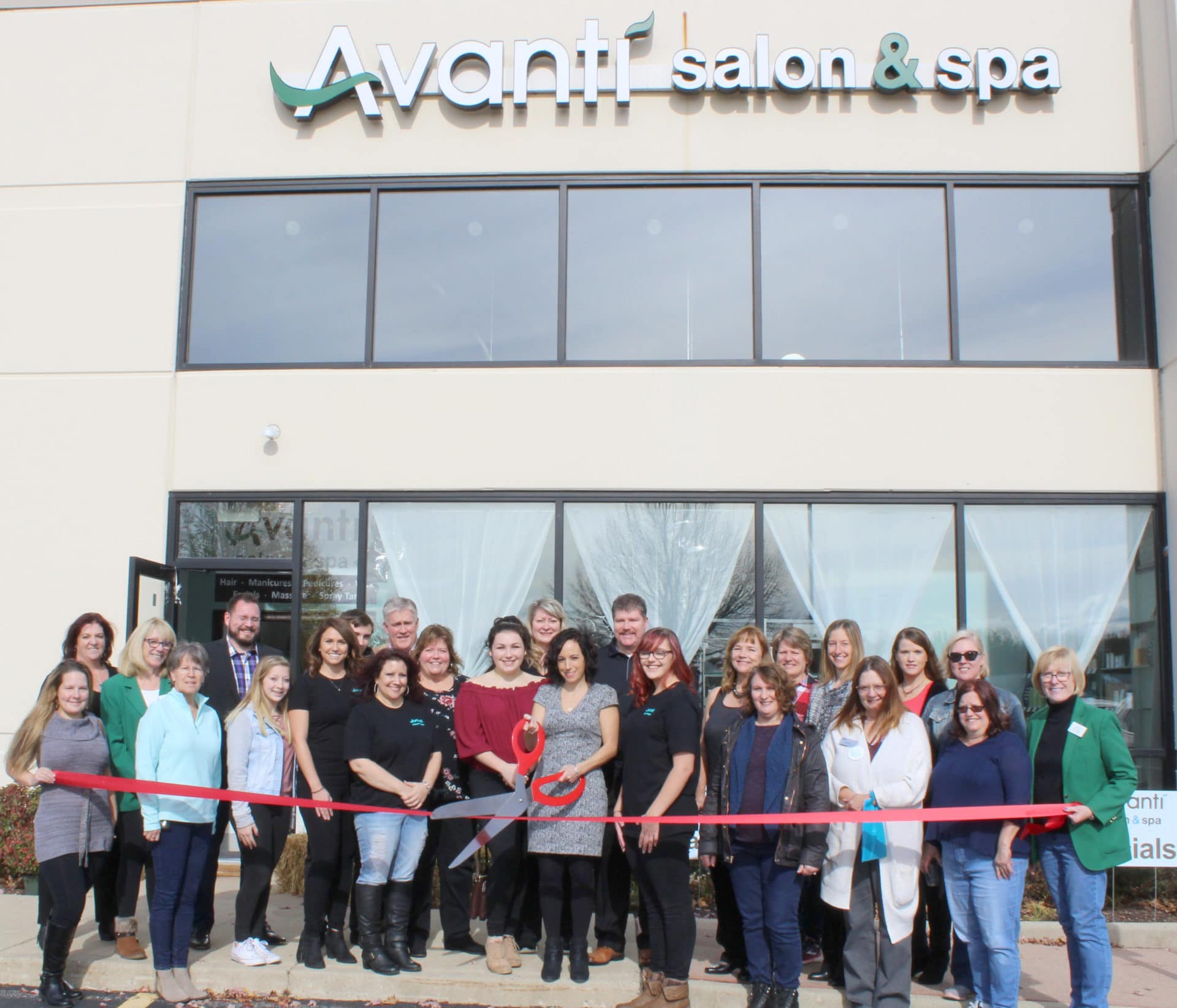 Avanti Salon team cutting red ribbon in front of building