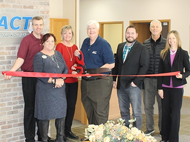 team cutting red ribbon