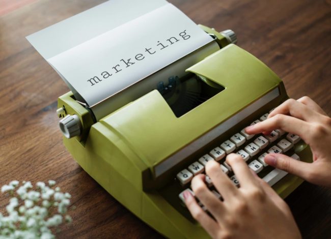 DS – 4 ways a marketing agency can help your business person typing "marketing" on green typewriter