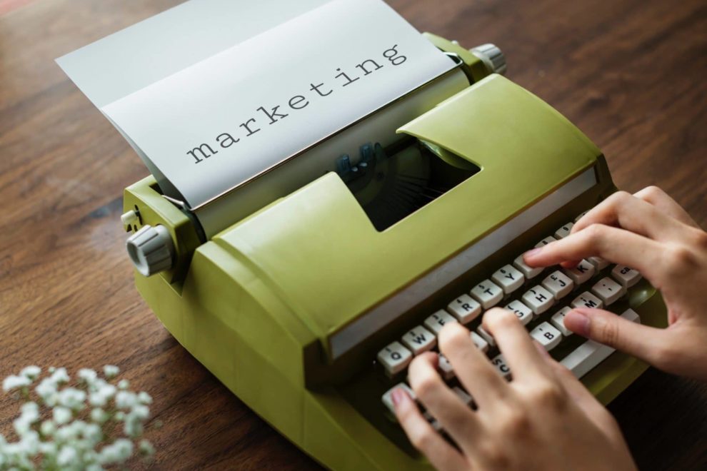 DS – 4 ways a marketing agency can help your business person typing "marketing" on green typewriter